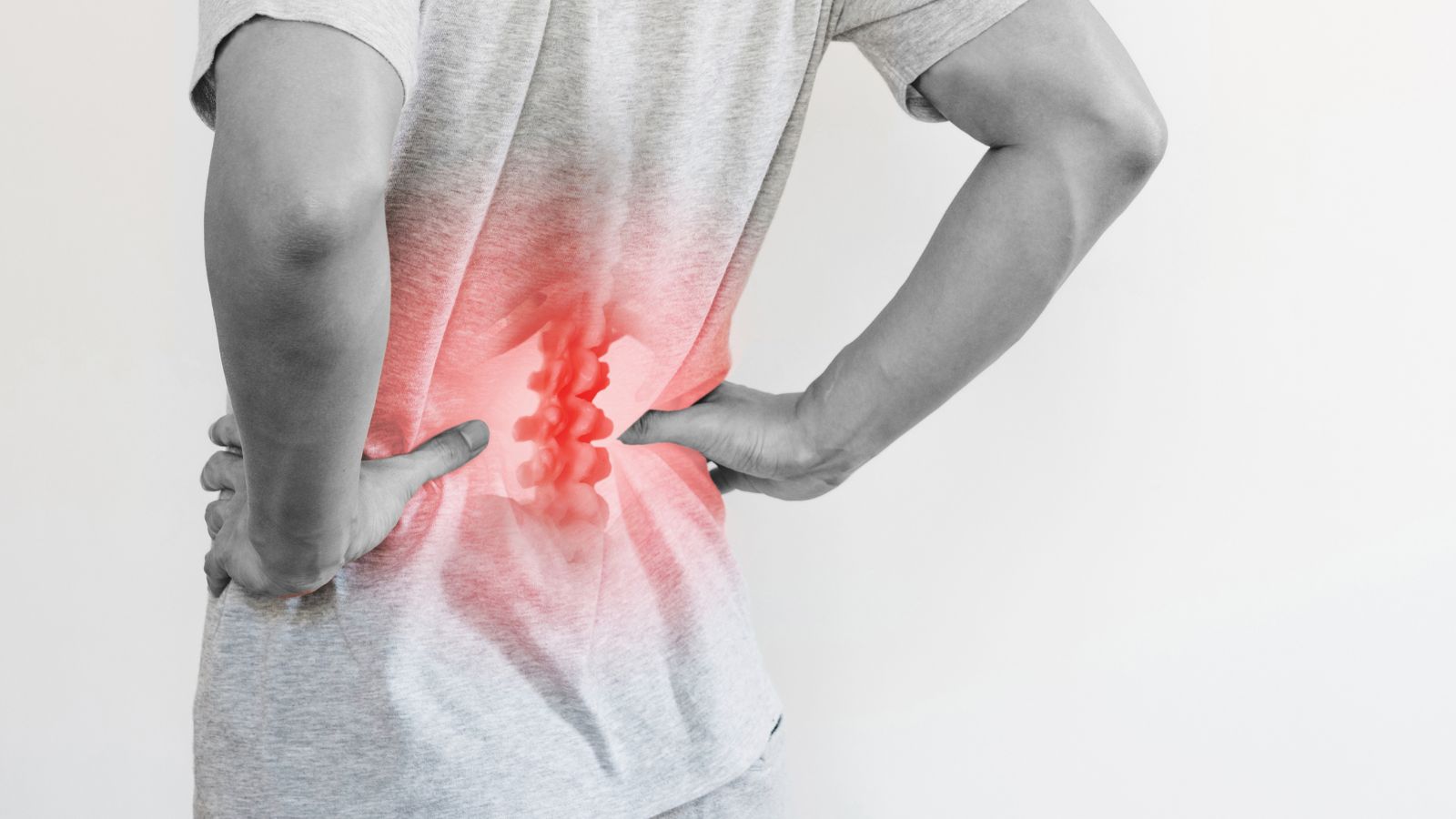 A man touched his lower back at the pain point because of the herniated intervertebral disc.